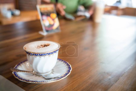 Téléchargez les photos : Tasse à café vintage blanche avec vue latérale sur ordinateur portable sur un bureau en bois - en image libre de droit
