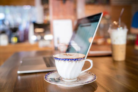 Photo for White vintage coffee cup with laptop side view on wooden desk - Royalty Free Image