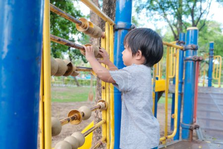 Photo for Happy preschool asian boy enjoying with outdoor slider in city park playground - Royalty Free Image