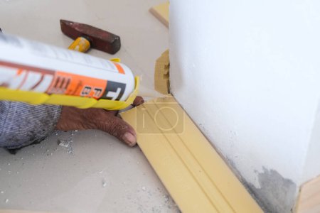 Téléchargez les photos : Homme mécanique main utiliser plancher de bois scellement design de bâtiment intérieur - en image libre de droit