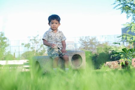 Foto de Adorable niño de 3 años jugando al aire libre parque de la ciudad naturaleza - Imagen libre de derechos
