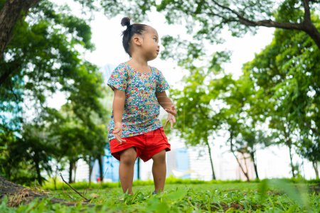 Téléchargez les photos : Petit tout-petit asiatique enfants fille jouer dans la ville public parc ensoleillé jour activité de plein air - en image libre de droit