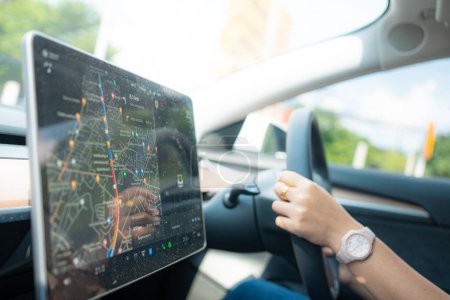 Téléchargez les photos : Femme conduire voiture utilisation navigateur GPS aide à l'écran dans la voiture voyage en toute sécurité - en image libre de droit