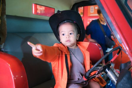 Photo for Little adorable asian girl play fire truck wear fire man career imagination of kid - Royalty Free Image