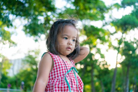 Téléchargez les photos : Heureuse fille de 2 ans profitant avec coucher de soleil en plein air dans le parc naturel - en image libre de droit