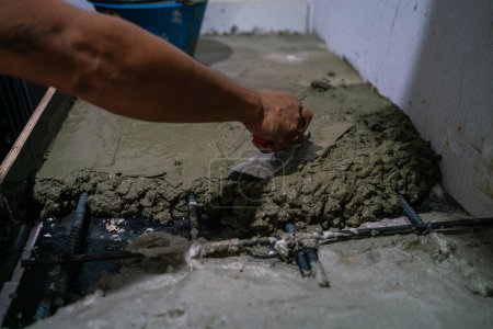 Foto de Hombre mecánico mano trenzado cemento piso interior edificio casa renovar - Imagen libre de derechos