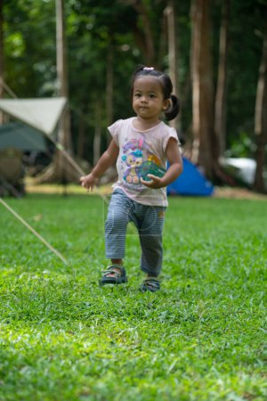 Téléchargez les photos : Petite fille asiatique profiter avec le camping dans la forêt de montagne activité de plein air - en image libre de droit
