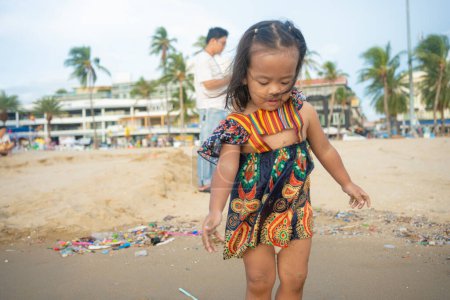Téléchargez les photos : Adorable fille asiatique jouissant de jouer sur la mer sable ville plage vacances d'été concept - en image libre de droit