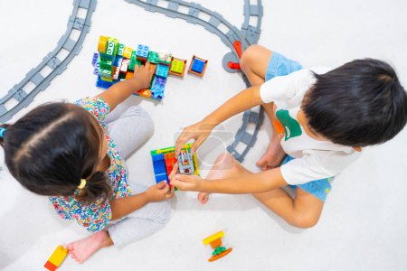 Téléchargez les photos : Adorable petit garçon et fille jouant en plastique bloc jouet construire imagination concept d'éducation - en image libre de droit
