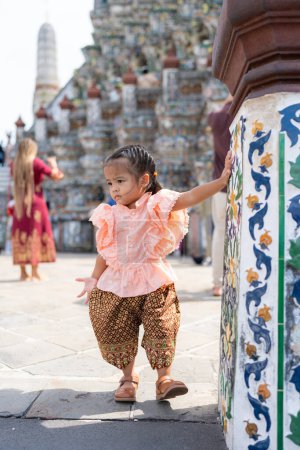 Foto de Adorable niña de jardín de infantes usan estilo tailandés traje de viaje en Wat Arun turismo viajes en Bangkok Tailandia - Imagen libre de derechos