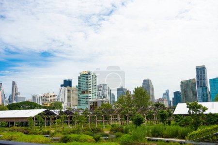 Téléchargez les photos : Benchakitti forêt tropicale humide dans le parc de la ville avec immeuble de bureaux moderne nouveau point de repère à Bangkok Thaïlande - en image libre de droit