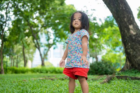 Téléchargez les photos : Petit tout-petit asiatique enfants fille jouer dans la ville public parc ensoleillé jour activité de plein air - en image libre de droit