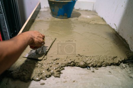 Téléchargez les photos : Homme mécanique main travaillant avec du ciment - en image libre de droit