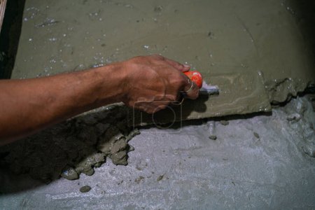 Téléchargez les photos : Homme mécanique main travaillant avec du ciment - en image libre de droit