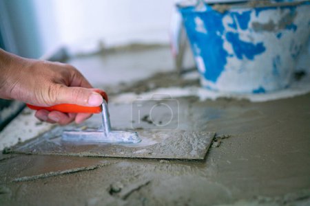 Foto de Hombre mecánico mano trenzado cemento piso interior edificio casa renovar - Imagen libre de derechos