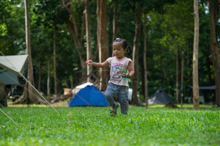 Téléchargez les photos : Petite fille asiatique profiter avec le camping dans la forêt de montagne activité de plein air - en image libre de droit