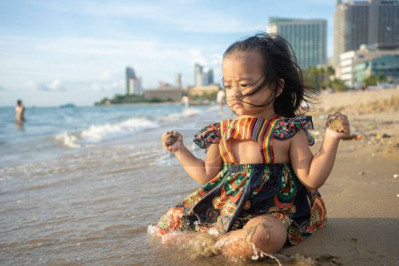 Photo for Adorable asian girl enjoying play on sea sand city beach summer vacation concept - Royalty Free Image