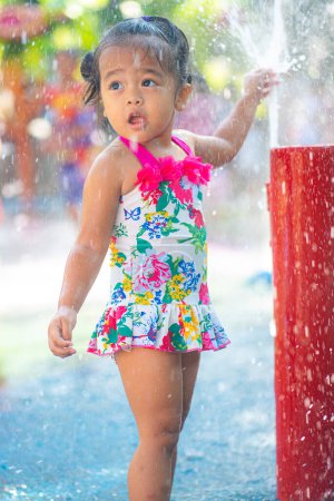 Photo for Beautiful asian toddler girl enjoying play outdoor city water park summer vacation - Royalty Free Image
