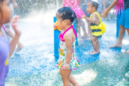 Photo for Beautiful asian toddler girl enjoying play outdoor city water park summer vacation - Royalty Free Image