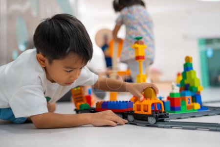 Foto de Adorable niño y niña jugando juguete bloque de plástico edificio imaginación concepto de educación - Imagen libre de derechos