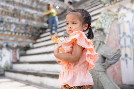Téléchargez les photos : Adorable fille de la maternelle porter Voyage costume de style thaïlandais à Wat Arun voyage touristique à Bangkok en Thaïlande - en image libre de droit