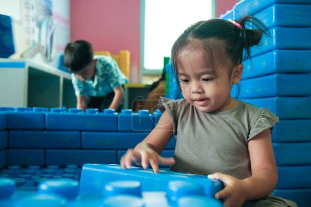 Photo for Adorable little girl enjoying with building toy block indoor playground happy preschool girl - Royalty Free Image