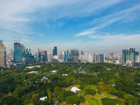 Photo for Aerial view of Lumphini Park backgrounded by the Silom area skyline office buildings, business district of Thailand's capital. - Royalty Free Image