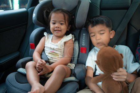 Téléchargez les photos : Petit enfant garçon et fille assis sur carseta avec ceinture de sécurité voyage concept de vacances - en image libre de droit
