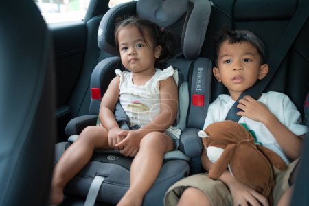 Téléchargez les photos : Petit enfant garçon et fille assis sur carseta avec ceinture de sécurité voyage concept de vacances - en image libre de droit