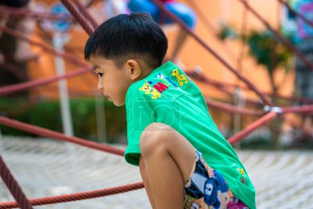Téléchargez les photos : Jardin d'enfants asiatique garçon profiter en ville aire de jeux en plein air vacances heureux apprentissage et exercice - en image libre de droit