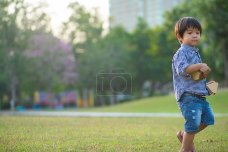 Foto de Asiático preescolar chico disfrutando al aire libre recreación ciudad parque al atardecer luz - Imagen libre de derechos