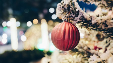 Téléchargez les photos : Boule de Noël sur branche de pin fond flou heureuse nouvelle année - en image libre de droit