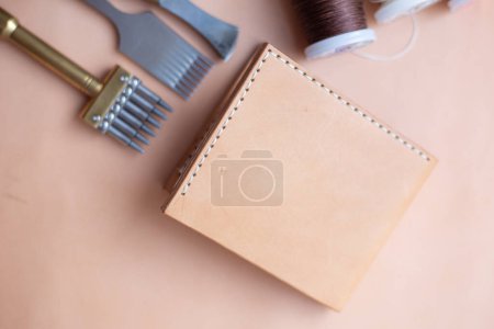 Téléchargez les photos : Genuine leather bifold money wallet with crafts tool craftmanship working - en image libre de droit