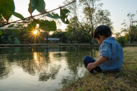 Téléchargez les photos : Tout-petit asiatique garçon jouer dans ville parc à rivière côté, de plein air loisirs - en image libre de droit