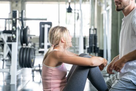 Foto de Deporte pareja sentarse juntos en fitness gimnasio hombre y mujer ejercicio juntos - Imagen libre de derechos