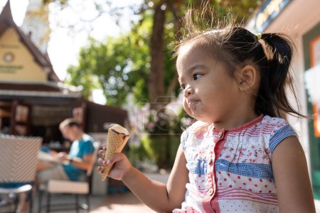 Photo for Happy asian preschool girl enjoying eat icecream travel in summer city - Royalty Free Image