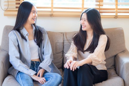 Téléchargez les photos : Heureux belle entreprise asiatique femme ami parler ensemble assis sur canapé assis dans maison bureau - en image libre de droit