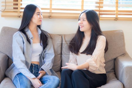 Photo for Happy beautiful business asian woman friend talking together sitting on sofa sitting in home office - Royalty Free Image