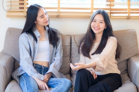 Photo for Happy beautiful business asian woman friend talking together sitting on sofa sitting in home office - Royalty Free Image