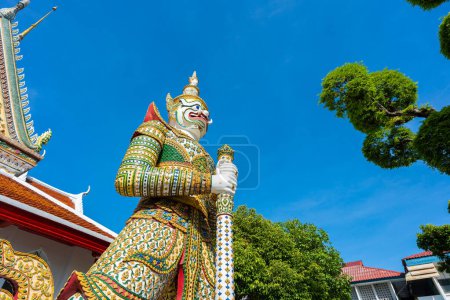 Téléchargez les photos : Portes de la salle d'ordination avec statues de géants, gardiens des démons à Wat Arun. Temple célèbre à Bangkok, Thaïlande. - en image libre de droit