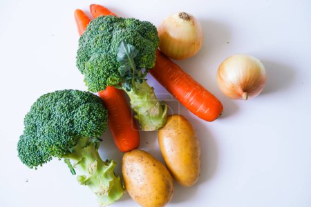 Foto de Grupo de verde brócoli calabaza amarilla y naranja zanahoria vegetal sobre fondo blanco - Imagen libre de derechos