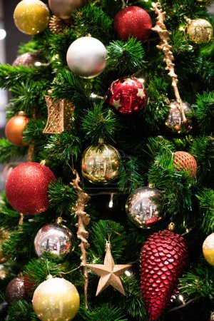 Foto de Concepto de celebración de Navidad con bola roja colgando decorar regalo en el fondo borroso de pino, vacaciones de invierno - Imagen libre de derechos