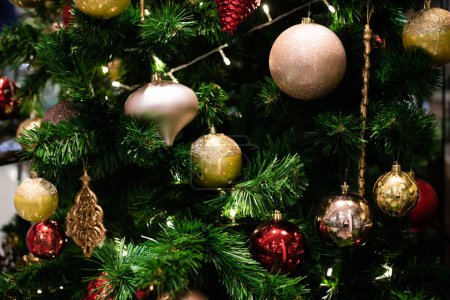 Foto de Concepto de celebración de Navidad con bola roja colgando decorar regalo en el fondo borroso de pino, vacaciones de invierno - Imagen libre de derechos