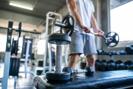 Téléchargez les photos : Sport homme levage haltère poids exercice salle de gym intérieure mode de vie sain - en image libre de droit