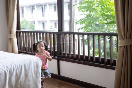 Téléchargez les photos : Adorable petite asiatique fille matin réveil dans confortable maison sur canapé avec couverture profiter fille - en image libre de droit
