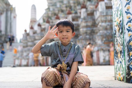 Photo for Little asiab boy wear traditional Thai suit travel in temple of dawn Wat arun Bangkok Thailand - Royalty Free Image