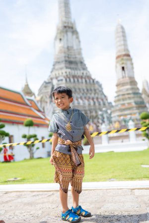 Photo for Little asiab boy wear traditional Thai suit travel in temple of dawn Wat arun Bangkok Thailand - Royalty Free Image