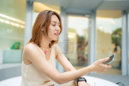 Foto de Negocio asiático mujer sentado al aire libre oficina café uso smartphone disfrutando de conexión a la red social - Imagen libre de derechos