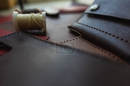 Téléchargez les photos : Véritable portefeuille en cuir tanné végétal de travail sur fond de cuir artisanat - en image libre de droit
