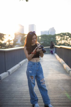 Photo for Photographer asian woman take outdoor photo with camera in city public urban park - Royalty Free Image